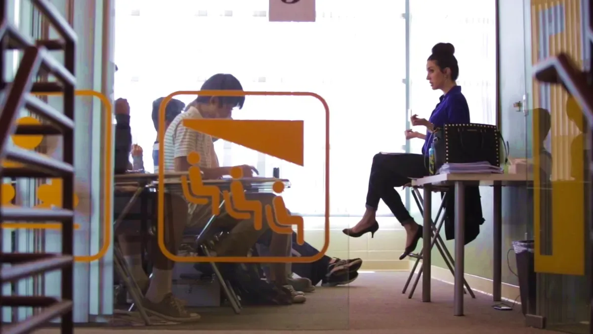 Students studying in a classroom behind a glass wall