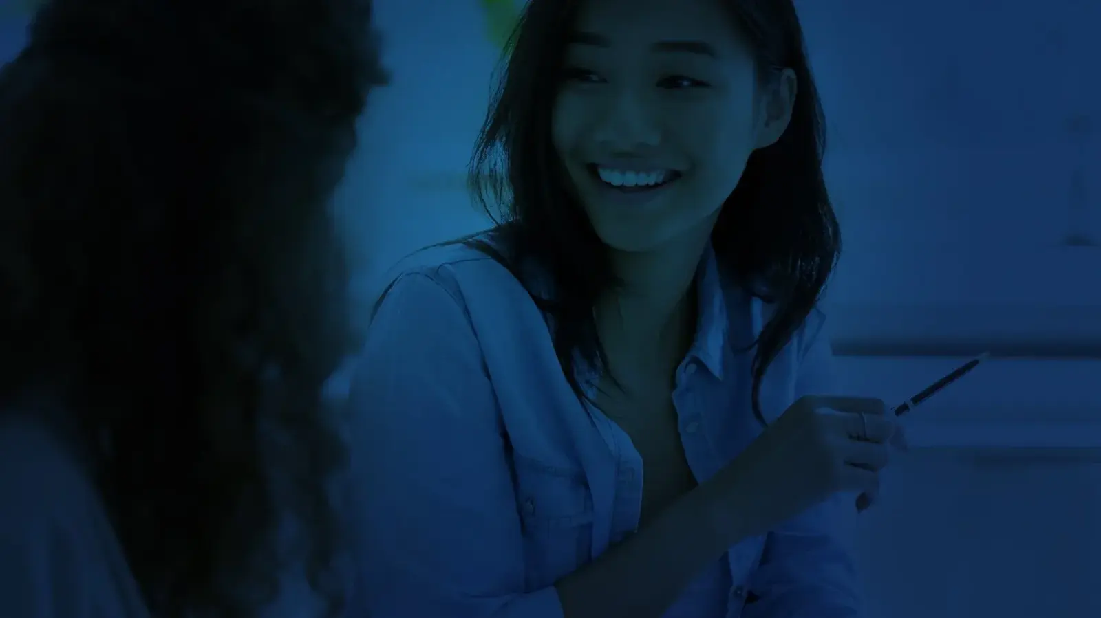 A student smiling while working through practice questions with an Elite Prep tutor.